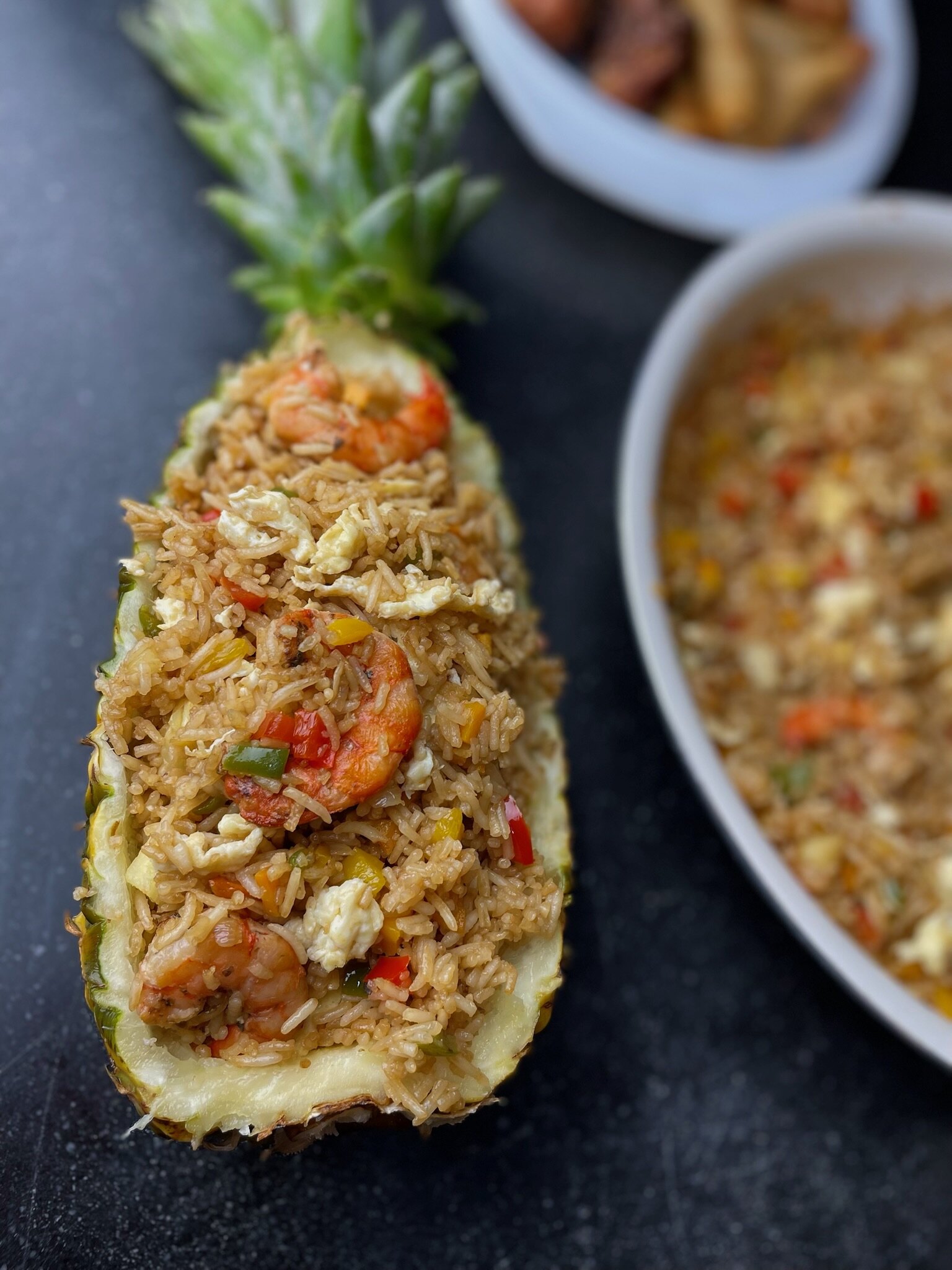 Fried rice with shrimp and peppers served inside a pineapple